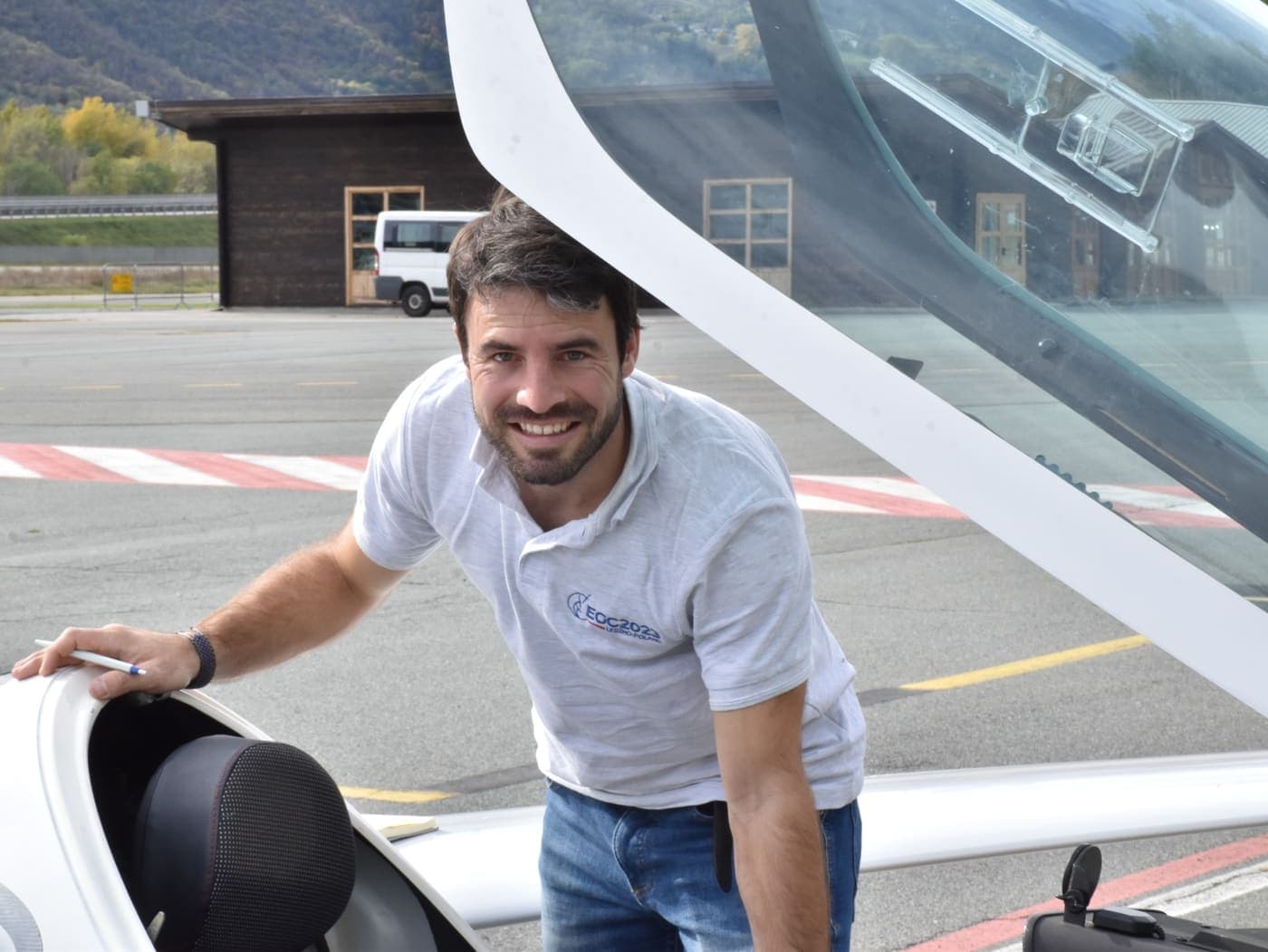 Gründer von Swiss Sailplane neben einer Segelflugzeug-Haube auf einem Alpenflugplatz